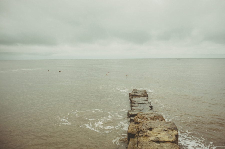 The groom and his ushers swimming at Lyme Regis in Dorset