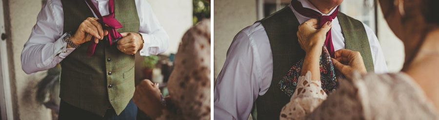 The bride's mother places a tie around her husbands neck