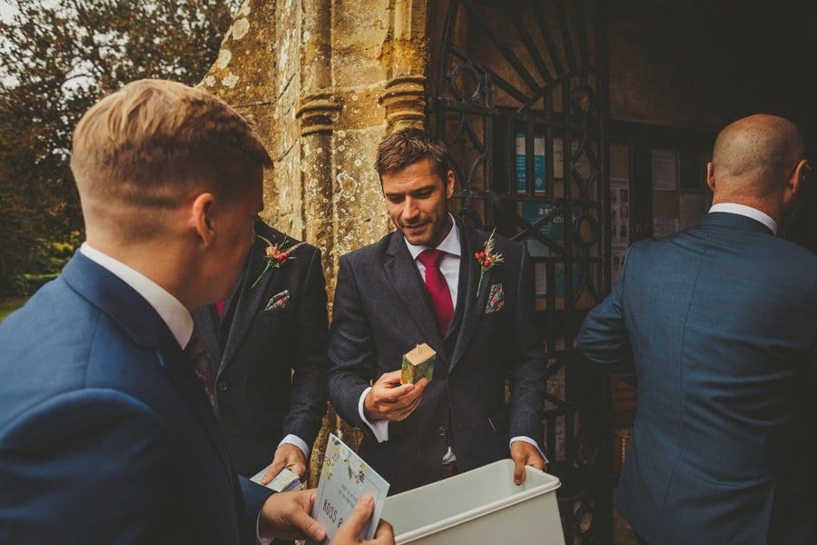 An usher picks up a gift for wedding guests outside the Church