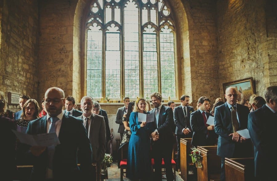 The wedding guests stand and sing a hymn in the Church