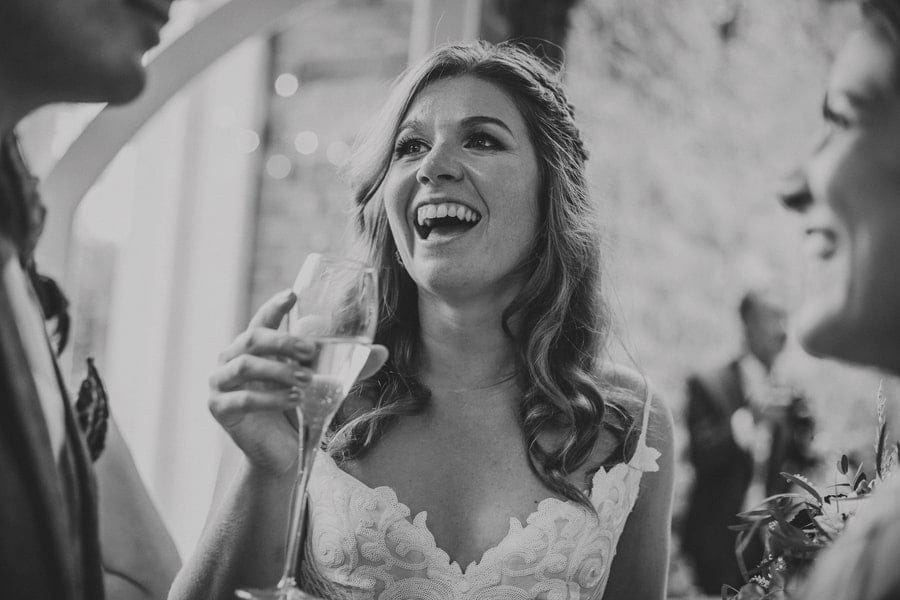 The bride laughs with wedding guests