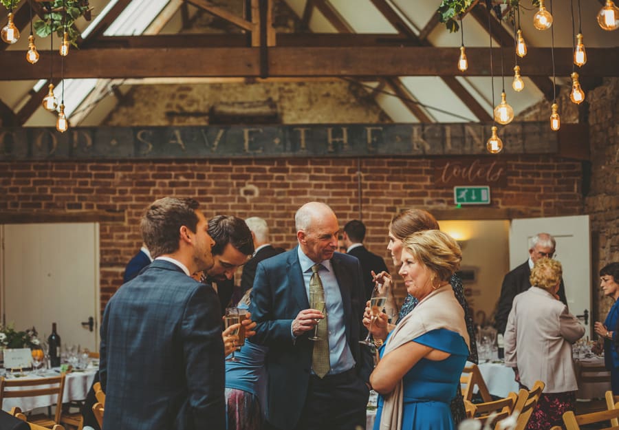 Wedding guests talk to each other in the Tithe Barn