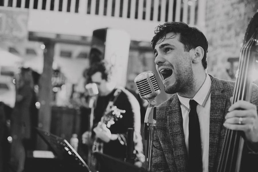 The singer of the wedding band performs a song to the wedding party