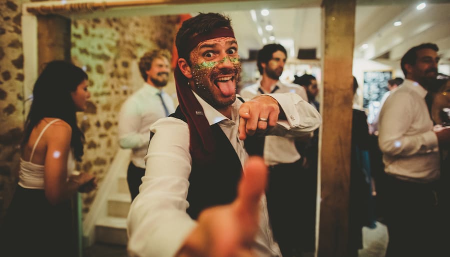 A wedding guest poses for a photograph on the dancefloor