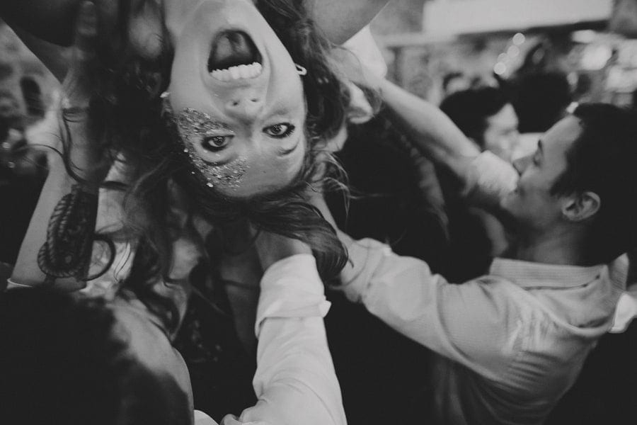 The bride screams as wedding guests lift her up