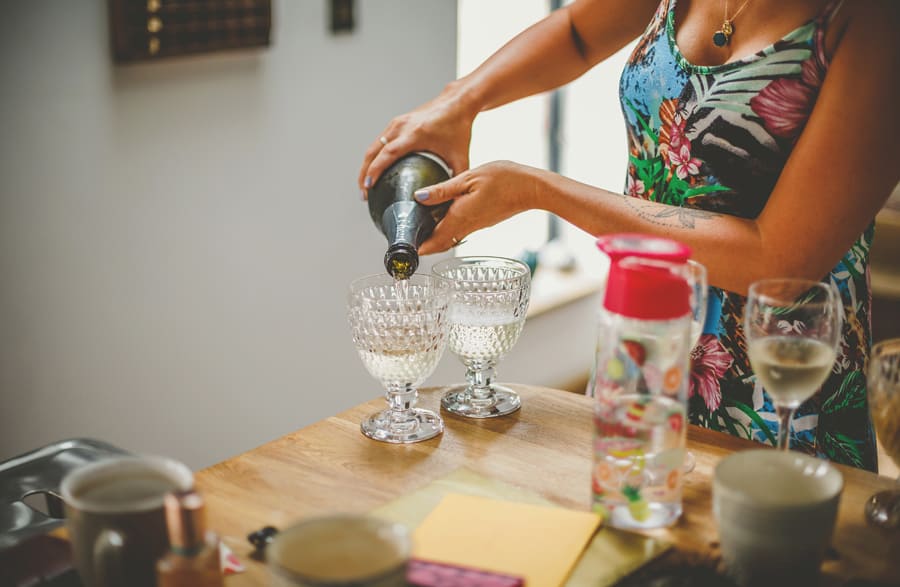 A bridesmaid pours champagne into glasses