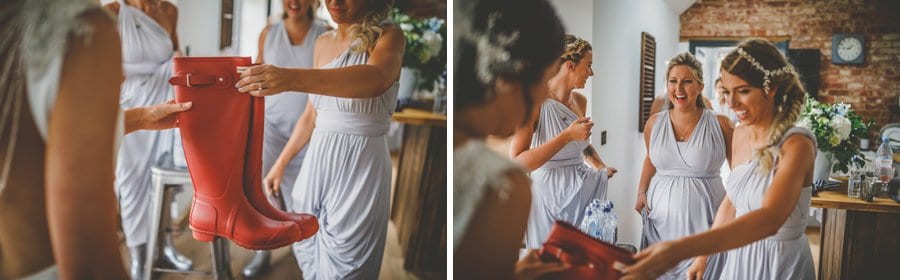 Bridesmaids give the bride a new set of red wellington boots in the kitchen of the cottage