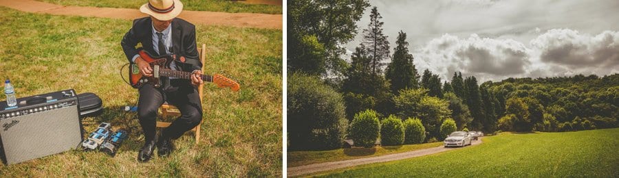 A guitarist plays his guitar as the wedding car with the bride in it arrives in the large open field
