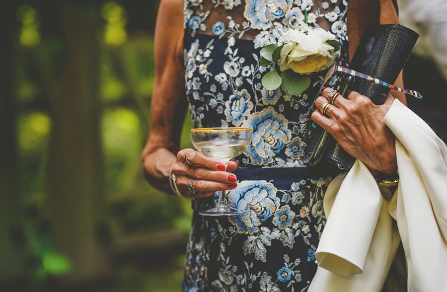 The grooms mother holds a glass of champagne in her right hand