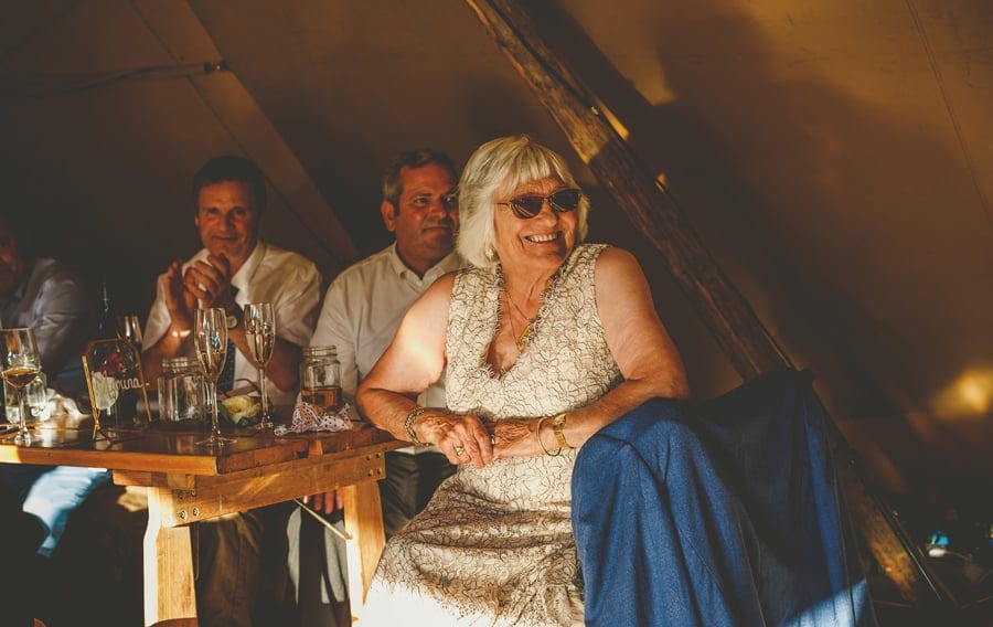The brides grandmother laughs at one of the speeches in the tipi