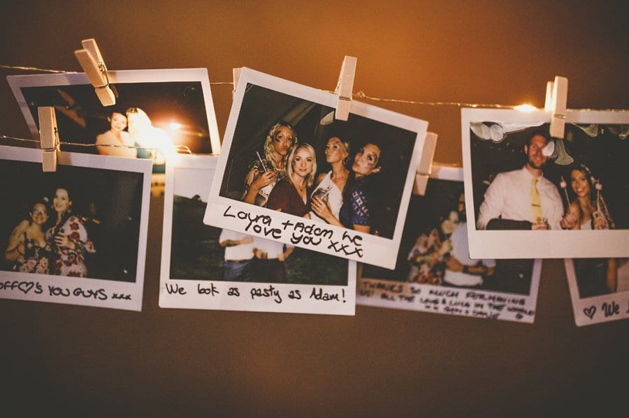 Polaroid photographs of the wedding day hang from string in the tipi at yurt retreat