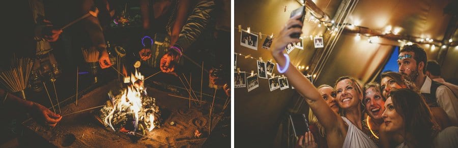A bridesmaid holds a mobile phone in her hand and takes a photograph of herself and her friends in the tipi at yurt retreat in Crewkerne in Somerset