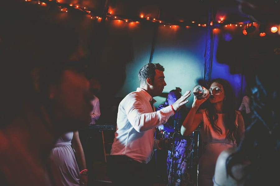 The bride drinks a bottle of alcohol on the dancefloor in the tipi