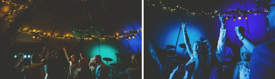 Wedding guests put their arms in the air on the dancefloor in the tipi and dance to a song played by the wedding band