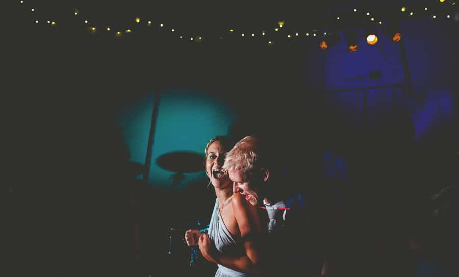 The groom puts his arms around a bridesmaid on the dancefloor in the tipi at yurt retreat