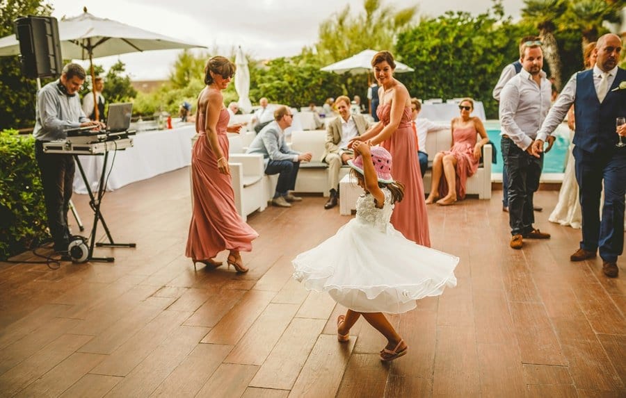 A flower girl dances with bridesmaids