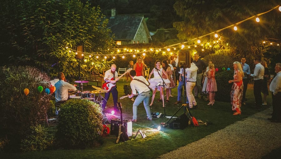 The wedding party dance on the lawn in front of the wedding band