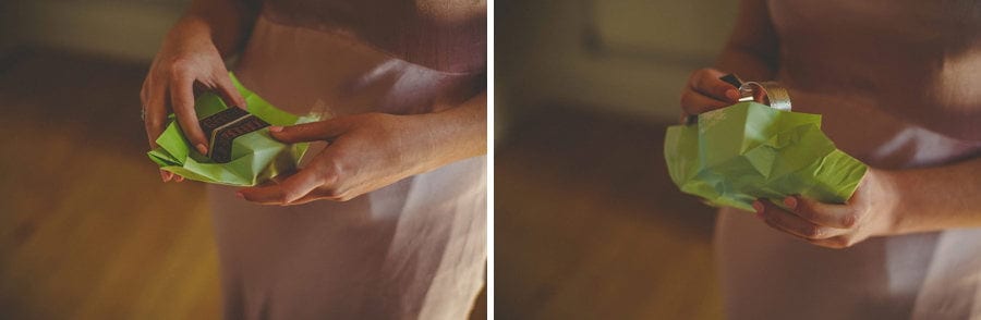 The bride opens a small gift wrapped in green paper