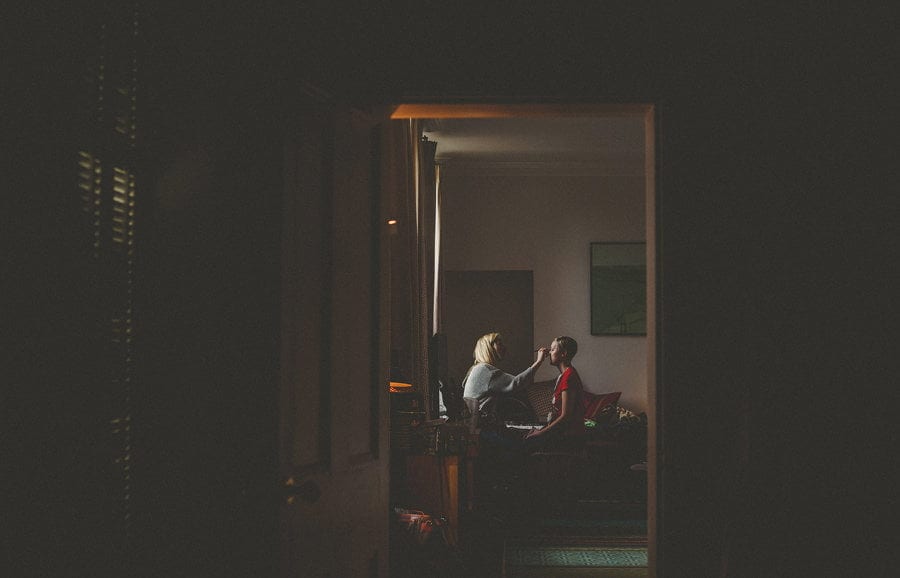 The bride has her makeup applied to her face at Cowley Manor