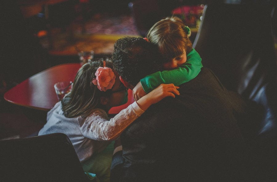Children embrace the groom at Cowley Manor