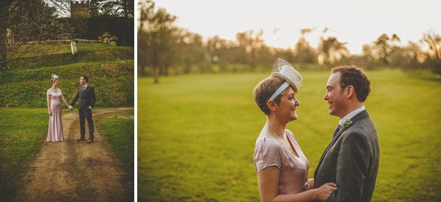 The bride and groom stand face to face with each other and pose for photographs on a field at Cowley Manor Estate.