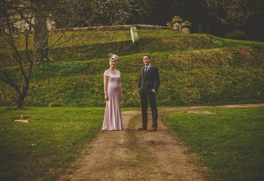 The bride and groom stand next to each other and pose for a photograph at the back of Cowley Manor Estate
