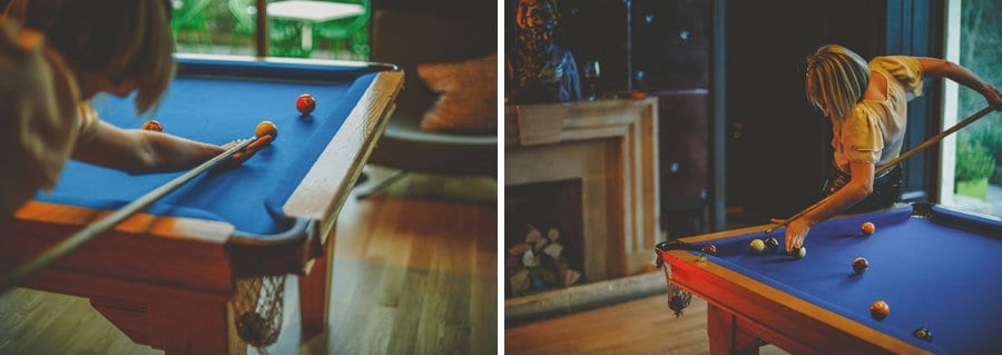 Wedding guests playing pool in the billiards room at Cowley Manor
