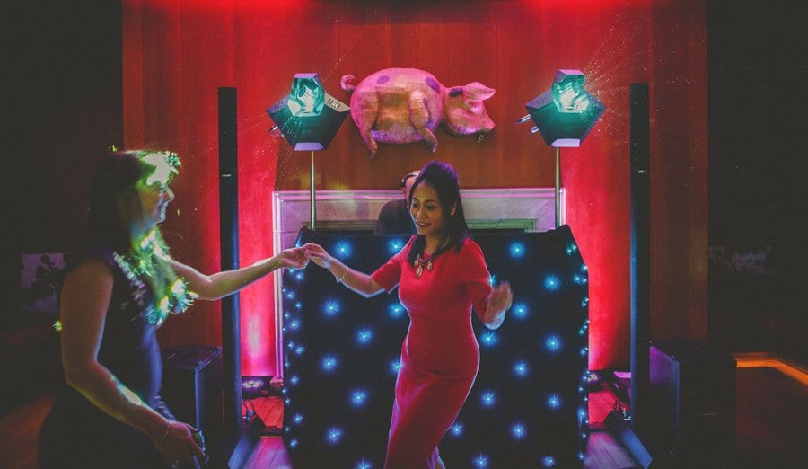 Wedding guests holding hands and dancing on the dancefloor