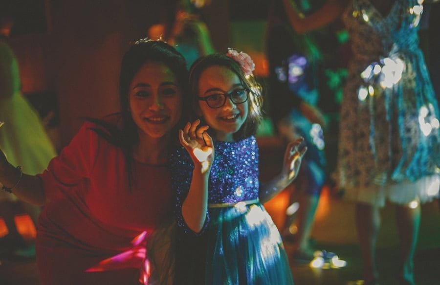 Wedding guests pose for photographs on the dancefloor at Cowley Manor