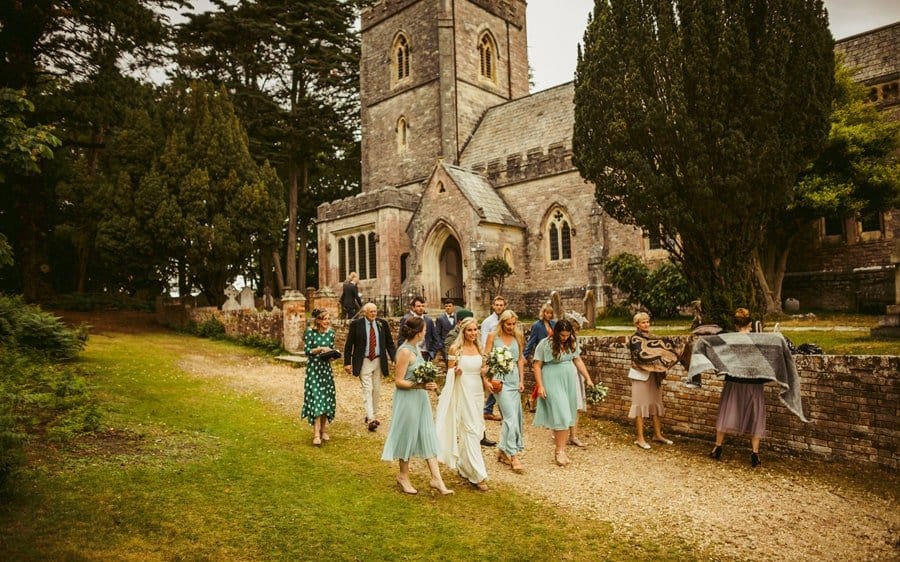 The bride and her bridesmaids walk away from the Church after the wedding ceremony