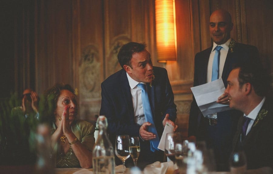 The groom standing up in front of the wedding table delivers his wedding speech at Cowley Manor