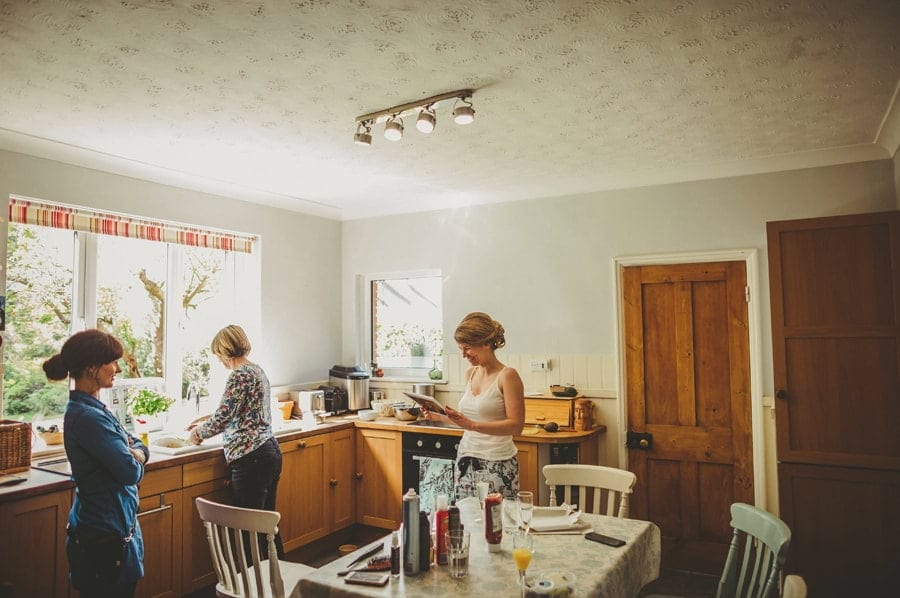 The bride looks at a photo album in the kitchen of her parents house