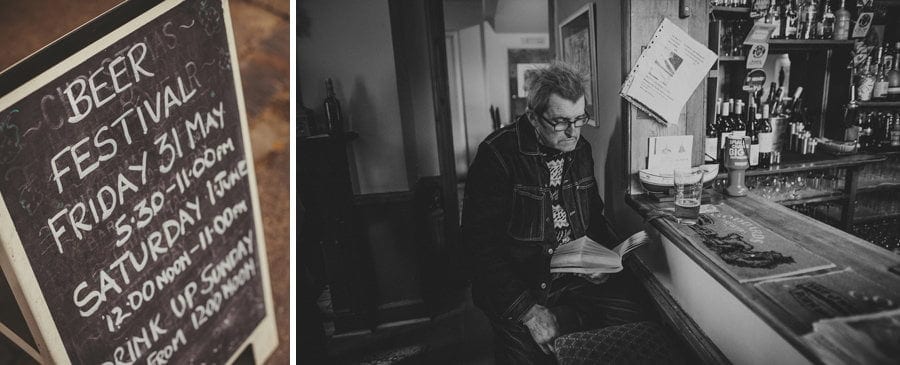 A sign outside a public house and a man sits at the bar and reads a book
