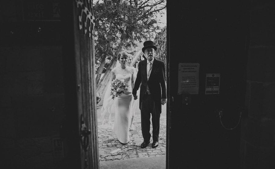The bride and her father stand at the door of the church and wait to go in