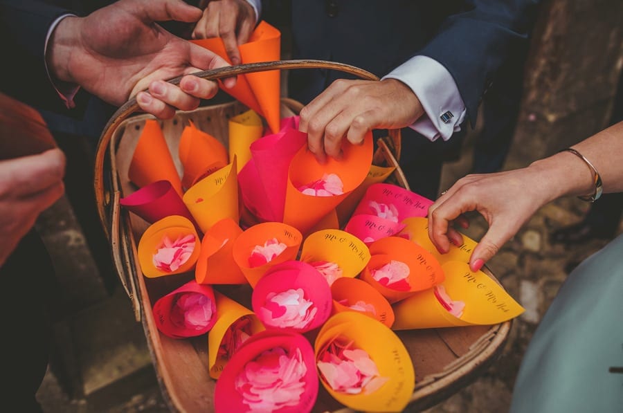 Wedding guests pick up paper cones from a wicker basket