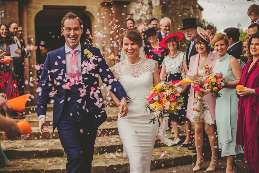 The bride and groom leave the church and are showered in confetti which is thrown by the wedding guests