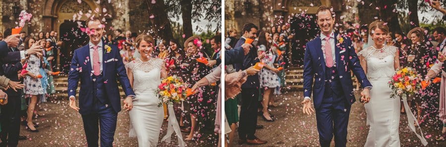 The bride and groom are covered in confetti outside the church