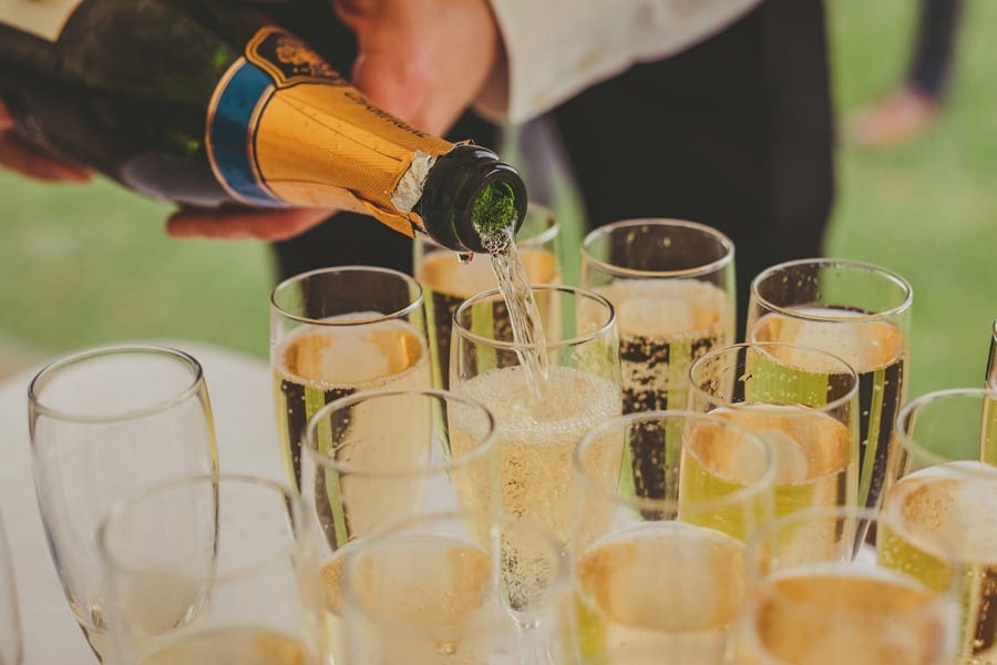 A lady pours champagne into glass flutes