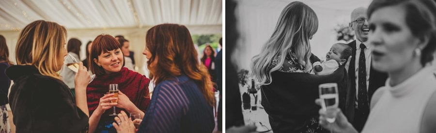 A lady holds a baby in her arms in the marquee