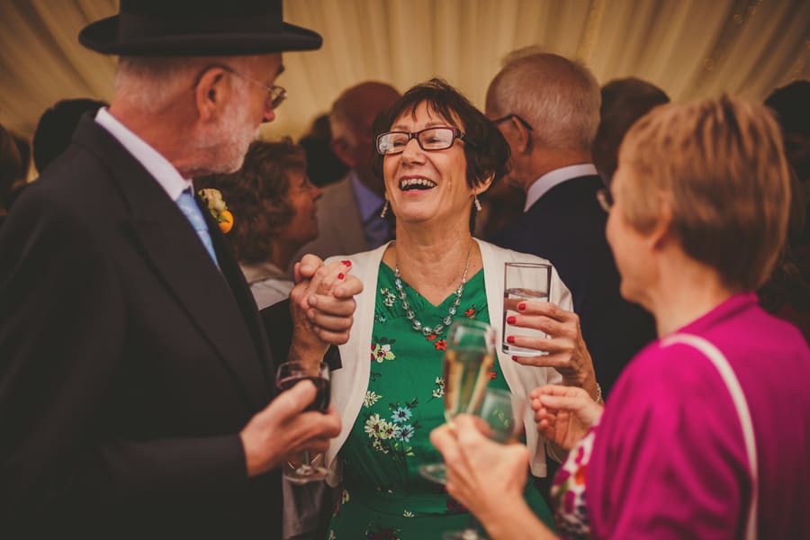 The brides father talks to friends outside the marquee