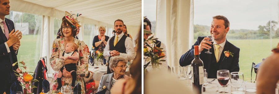An usher listens to the wedding speeches sat at the table in the marquee