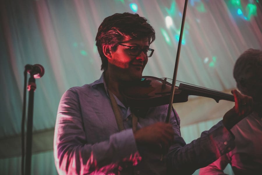 A member of the wedding band plays violin on stage