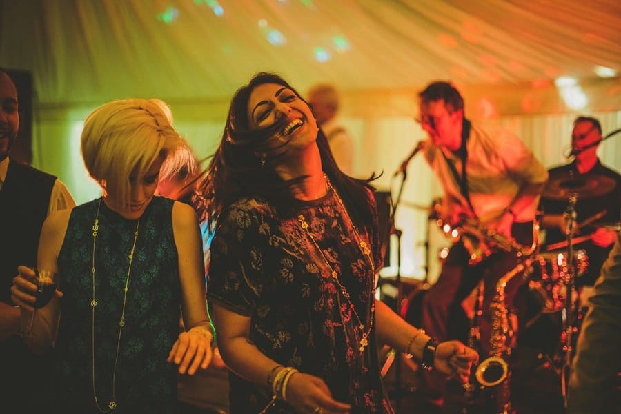 Two ladies dance next to each other in the marquee