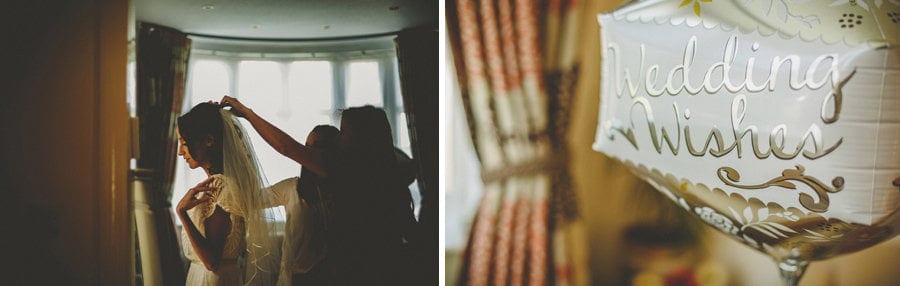 The brides sister fastens the veil onto the head of the bride in their parents house