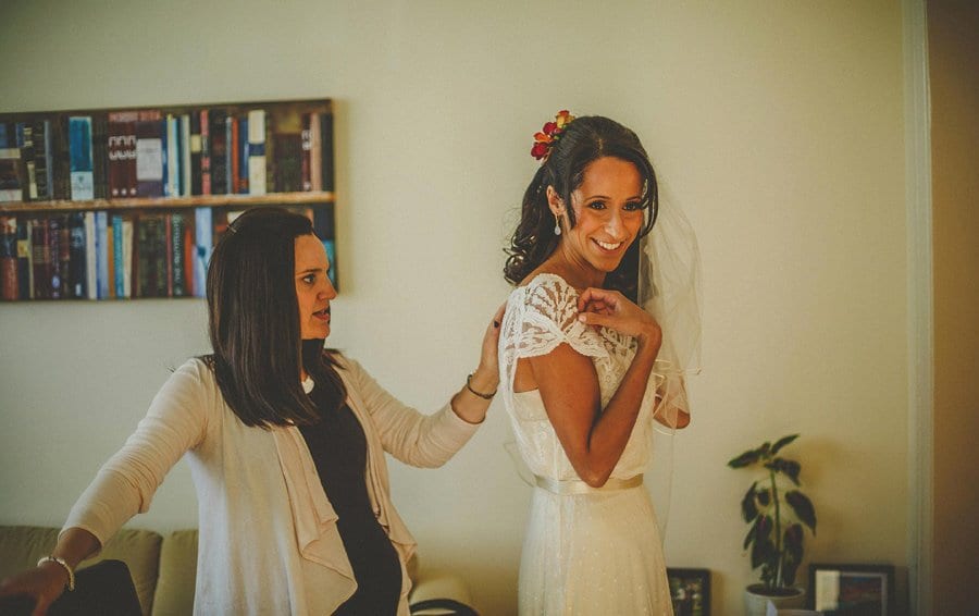 The bride smiles as she listens to a friend share a joke with her