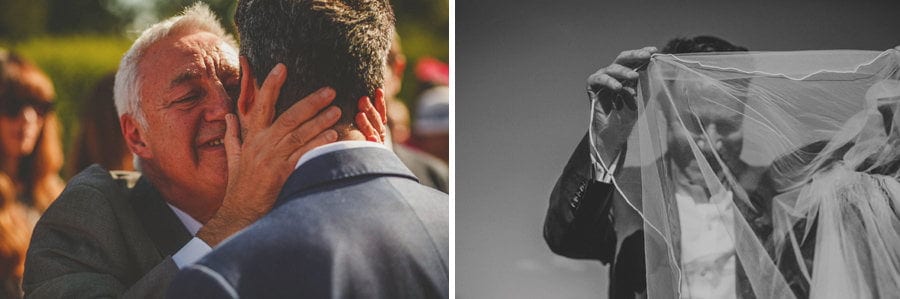 The groom's father kisses his son at the outdoor wedding ceremony at Micklefield Hall