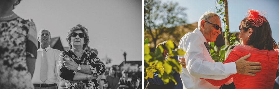 Wedding guests stand and watch the outdoor wedding ceremony
