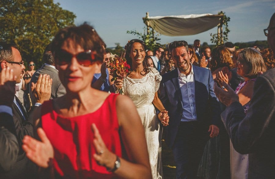 The bride and groom walk down the aisle together at the end of the outdoor wedding ceremony at Micklefield Hall