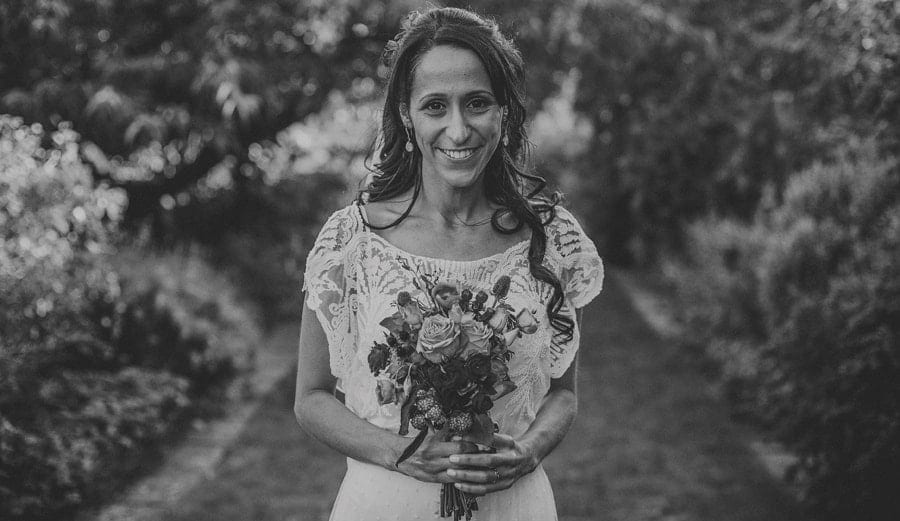The bride poses for a photograph in the gardens at Micklefield Hall