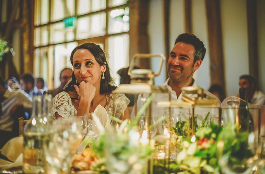 The bride and groom sit at the wedding table and listen to the speeches